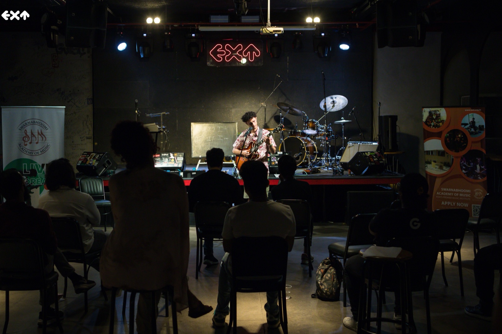 Lucas Baret en concert, guitare électrique à la main, sur la scène d'un club